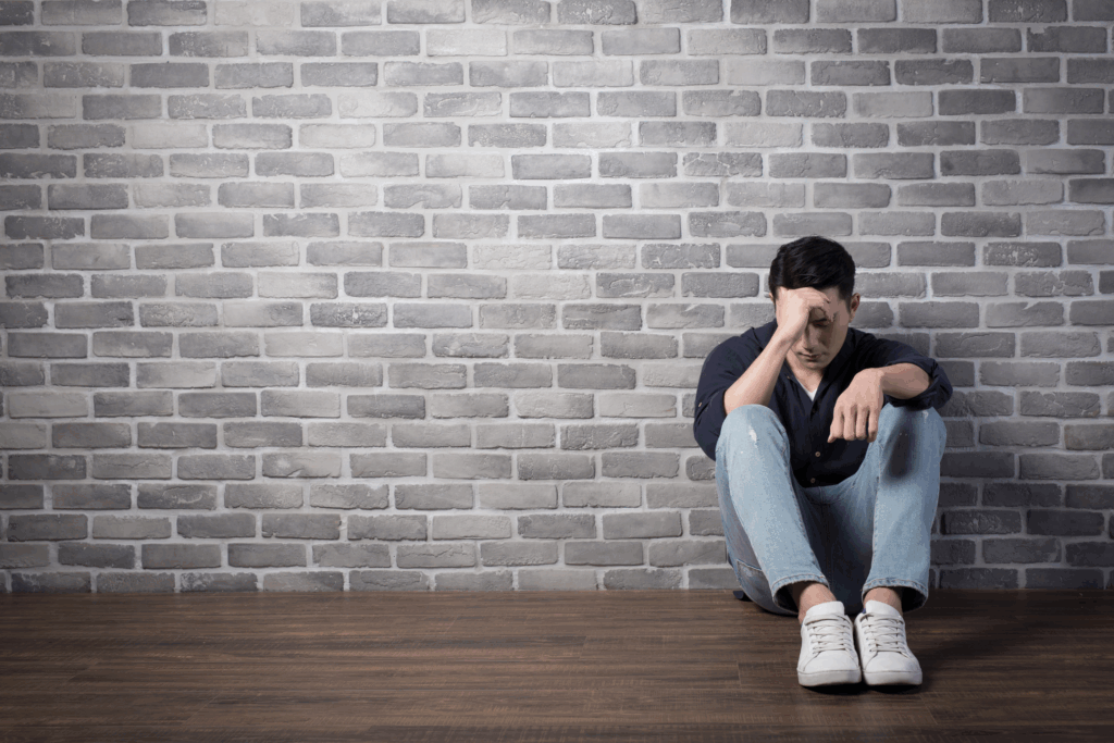 depression - the image shows a man on the floor with his head in his hand clearly sad